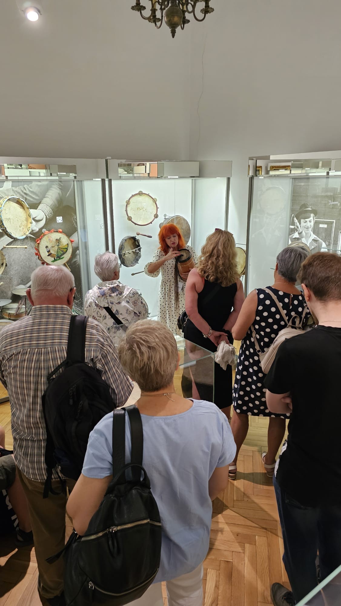 Przewodnik prezentujący burczybas grupie zwiedzających w Komnacie Radziwiłłów I.