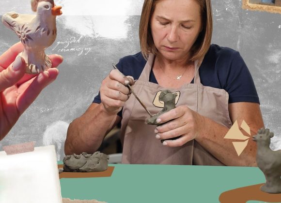 Zdjęcie. Kobieta siedząca za stołem. W prawej ręce trzyma drewniane narzędzie, którym formuje figurkę ptaka z gliny.