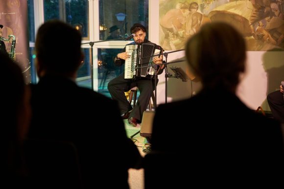 Akordeonista z zespołu Czarnina oraz publiczność podczas koncertu w Muzeum Ludowy Instrumentów Muzycznych