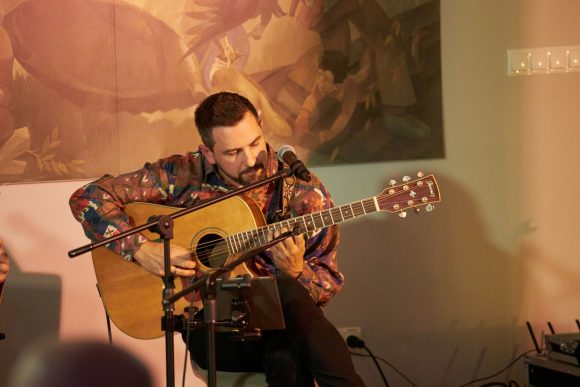 Gitarzysta z zespołu Czarnina oraz publiczność podczas koncertu w Muzeum Ludowy Instrumentów Muzycznych