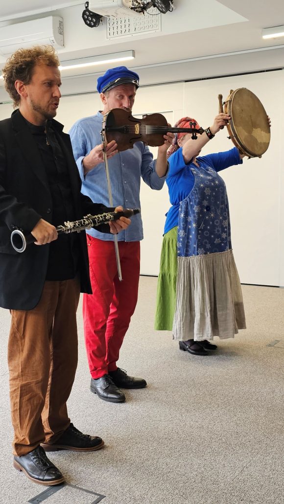 Aktorzy z teatrzyku „Słuchaj uchem” prezentujący instrumenty klarnet, skrzypce i bębenek podczas spektaklu „Kusy Janek”.