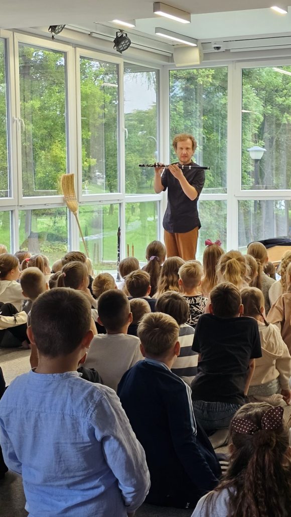 Aktor z teatrzyku „Słuchaj uchem” prezentujący klarnet oraz dziecięca publiczność podczas spektaklu „Kusy Janek”.