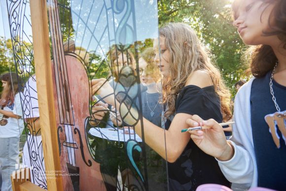 Na pierwszym planie uczniowie Publicznej Szkoły Podstawowej nr 2 im. Jana Pawła II w Szydłowcu podczas zajęć artystycznych „Witraż w plenerze”.
