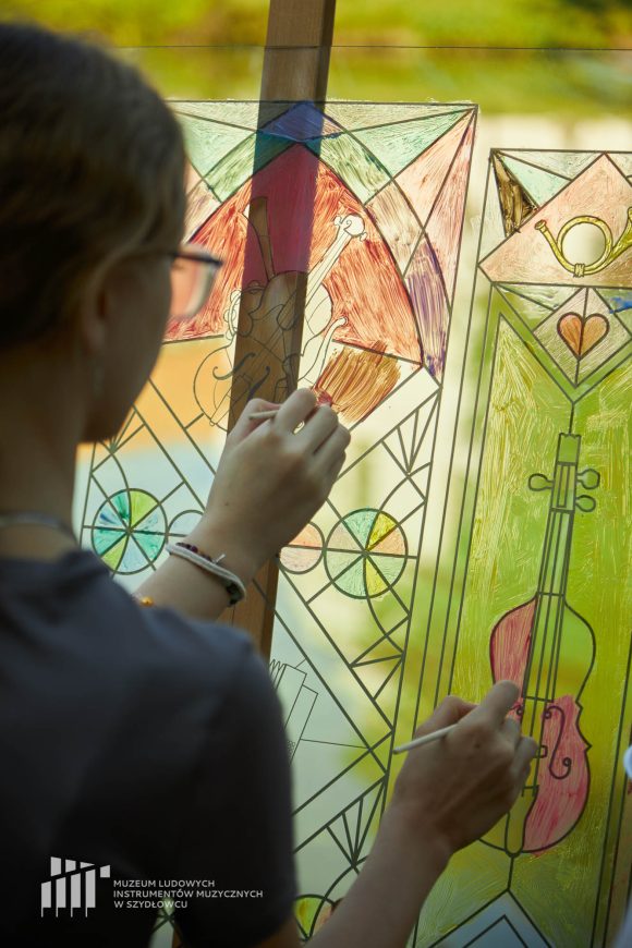 Na pierwszym planie uczniowie Publicznej Szkoły Podstawowej nr 2 im. Jana Pawła II w Szydłowcu podczas zajęć artystycznych „Witraż w plenerze”.