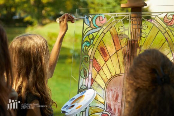Na pierwszym planie uczniowie Publicznej Szkoły Podstawowej nr 2 im. Jana Pawła II w Szydłowcu podczas zajęć artystycznych „Witraż w plenerze”.