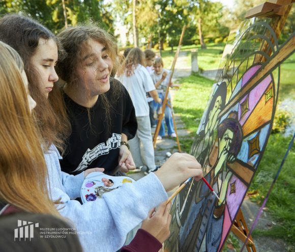 Na pierwszym planie uczniowie Publicznej Szkoły Podstawowej nr 2 im. Jana Pawła II w Szydłowcu podczas zajęć artystycznych „Witraż w plenerze”.