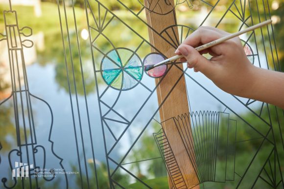 Na pierwszym fragment pracy uczniów Publicznej Szkoły Podstawowej nr 2 im. Jana Pawła II w Szydłowcu podczas zajęć artystycznych „Witraż w plenerze”. W tle fosa i fragment zamku.