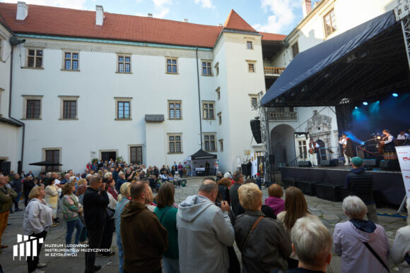 Ujęcie z boku na publiczność i scenę. W tle zachodnie skrzydło szydłowieckiego zamku.