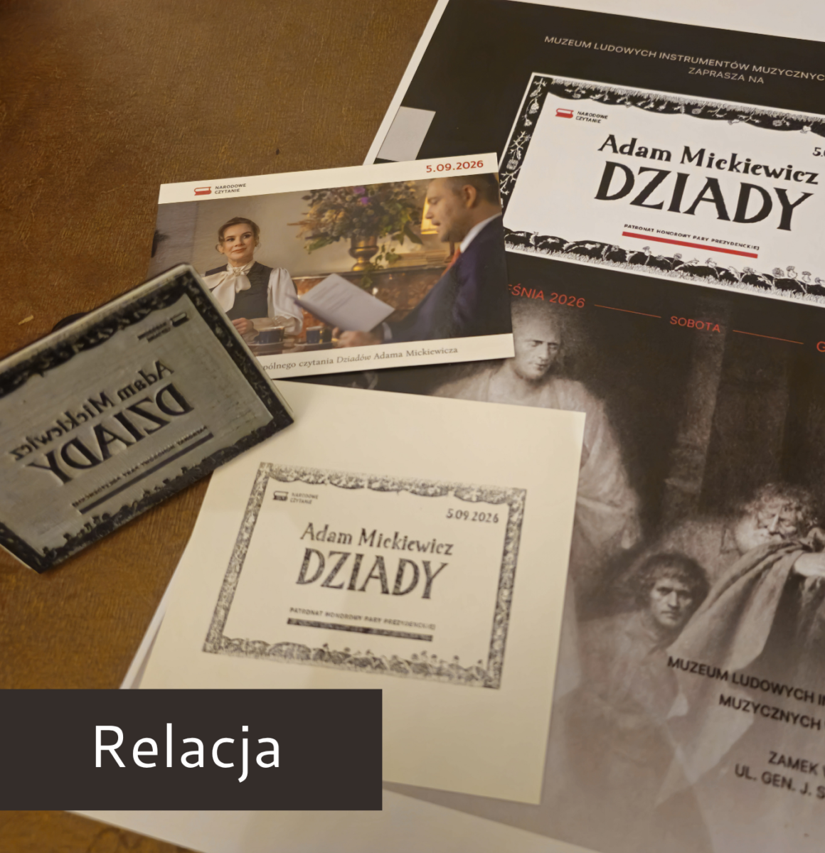 Dziady A.Mickiewicz Fotografia przedstawia plakat Narodowego Czytanie, zdjęcie pary prezydenckiej oraz piątkę promującą Narodowe Czytanie